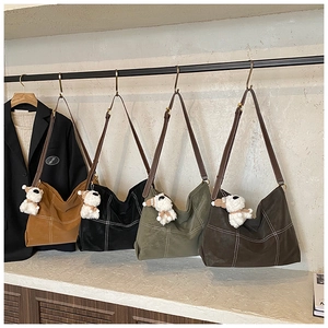 Détail de grands sacs cabas en toile en quatre couleurs avec surpiqûres et charms chien