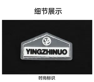Close-up of white rubber brand patch with logo on durable black nylon fabric
