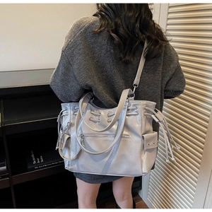 Détail du grand sac cabas gris brillant avec cordons latéraux et bandoulière réglable