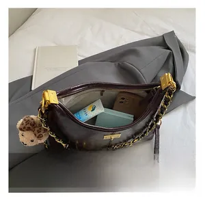 Internal capacity of retro brown leather shoulder bag with gold chain and essentials