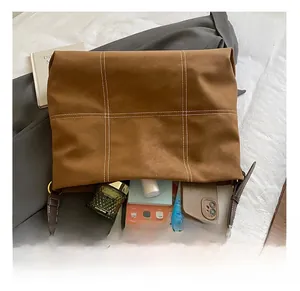 Détail de l'intérieur spacieux du sac cabas marron caramel avec tablette et maquillage