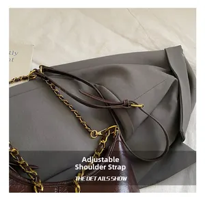 Close-up of the adjustable strap feature on a vintage brown leather shoulder bag