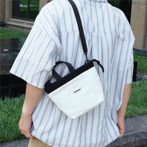 Outdoor lifestyle shot of a lightweight nylon crossbody bag in a black and white design