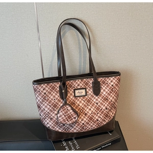 Detail of pink plaid tote bag with star patterns and a heart-shaped coin purse pendant