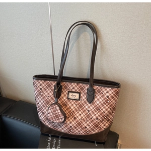 Detail of heart-shaped coin purse attachment and star print on brown tote bag