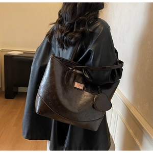 Deep brown tote bag with embossed cat patterns and Sunny Day label shown in a lifestyle view