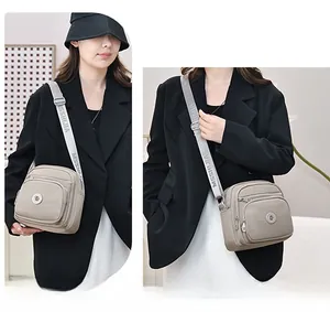 Detailansicht der Nylon-Umhängetasche mit Reißverschlussfächern und Marken-Schultergurt