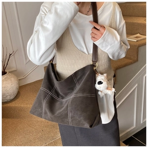 Détail du grand sac cabas gris foncé avec coutures blanches contrastées et porte-clé chien