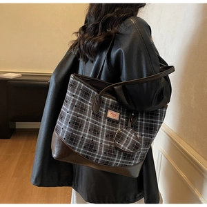 Detail of checkered tote bag with Sunny Day logo and matching charm on model