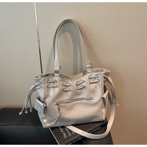 Détails des poches à cordon et des rivets argentés sur le grand sac fourre-tout gris