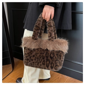 Detail of plush faux fur leopard print handbag with brown fluffy trim and handle