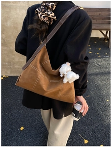 Détail du sac cabas marron en similicuir avec surpiqûres blanches et charme de chien