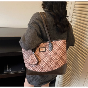 Detailed view of brown checkered tote bag with star patterns and heart-shaped coin purse
