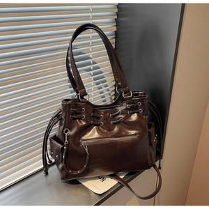 Détail du sac cabas vintage en cuir ciré marron avec cordon et œillets