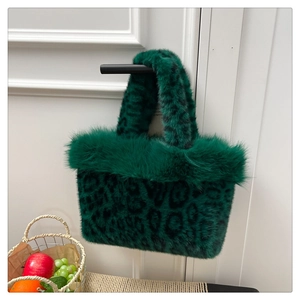 Close-up of leopard print faux fur handbag with plush trim hanging on a black handle
