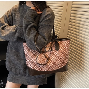 Detail view of plaid tote bag with heart charm shown on shoulder for daily use