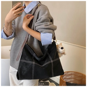 Vue détaillée du grand sac cabas noir avec surpiqûres blanches et charme de peluche