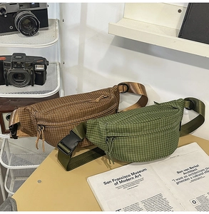Κοντινό πλάνο ρετρό καρό τσάντας μέσης με vintage φωτογραφική μηχανή στο φόντο