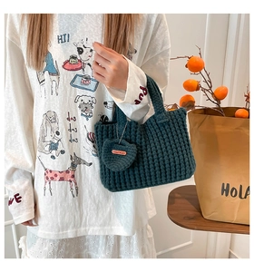 Close-up of handmade knit tote bag texture with heart charm and leather label