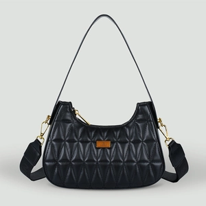 Détail du sac à bandoulière noir matelassé avec des ferrures dorées et texture chic