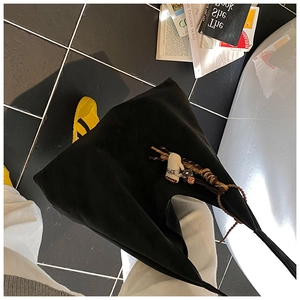 Detail of a black large capacity canvas hobo bag featuring a Coffee letter charm decoration