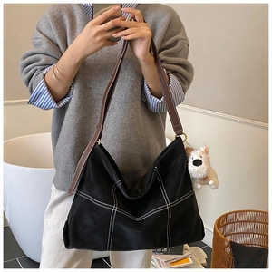 Détail du grand sac cabas noir à coutures quadrillées blanches et lanières marron