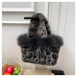 Furry leopard print handbag detail with grey plush trim hanging on a black handle