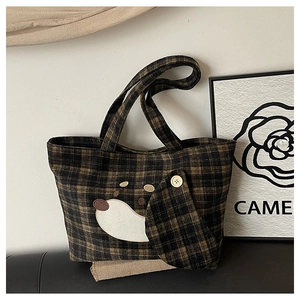 Detail der süßen Hunde-Stickerei und des Knopfakzents auf der karierten Woll-Tote-Bag