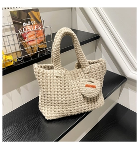 Detail of beige crochet tote bag showing square knit texture and handmade leather tag