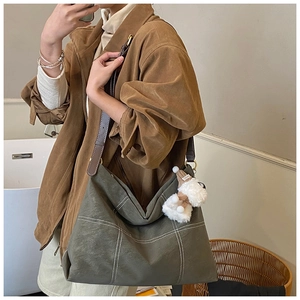 Détail du grand sac cabas vert olive avec coutures blanches et petit charme chien