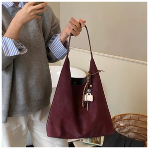Detail view of burgundy faux suede hobo bag with unique coffee cup charm accessory