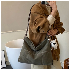 Détail du sac cabas matelassé vert olive avec surpiqûres blanches et charme peluche