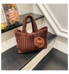Detail of dark brown crochet handbag featuring thick yarn texture and handmade charm