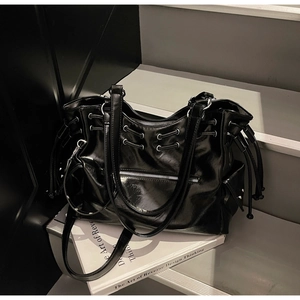 Détail d'un grand cabas noir brillant avec fermetures éclair et cordon de serrage style tech