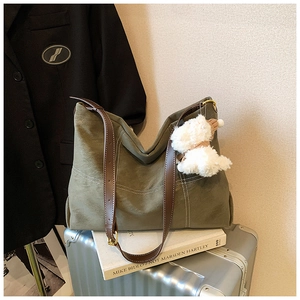 Détail du grand sac cabas vert olive avec coutures blanches et pendentif chiot peluche