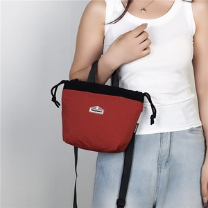 Detail of red and black waterproof nylon crossbody bag with adjustable strap and logo