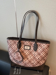 Brown plaid tote bag with star patterns and a heart-shaped coin purse on the shoulder strap