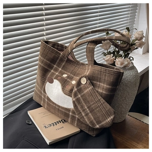 Detail der süßen Hunde-Stickerei auf der braun karierten Woll-Tote-Bag im weichen Licht