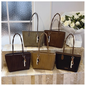Detailed view of textured tote bags in five colors with stylish beaded tassels
