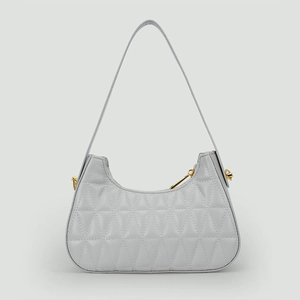 Détail du sac croissant matelassé gris argenté avec ferrures dorées et coutures fines