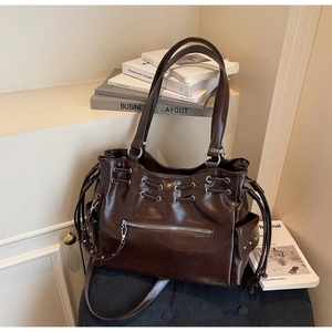 Vue détaillée du grand sac cabas en similicuir marron avec fermeture éclair et œillets