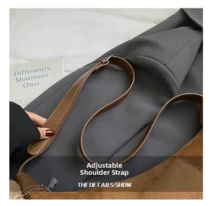 Detail of adjustable leather shoulder strap with silver buckle on brown suede handbag