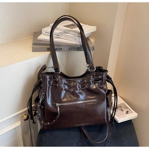 Détail du sac cabas marron foncé aspect cuir huilé avec poches zippées et œillets