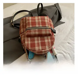 Detail view of plaid backpack showing large capacity with daily essentials inside