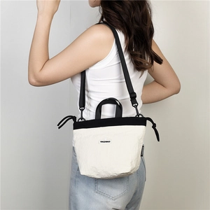 Detail of a black and white nylon crossbody bag showing the unique wrinkled texture and strap