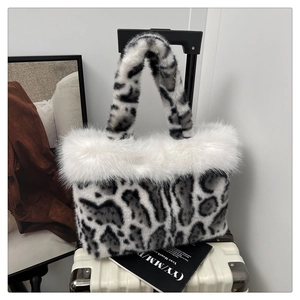 Detail of plush leopard print faux fur tote bag with fluffy white trim on a suitcase