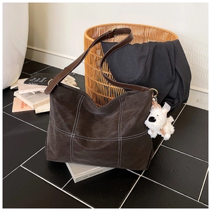 Détail du grand sac cabas marron avec surpiqûres blanches et pendentif chiot en peluche