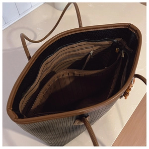 Detail view of the large tote bag showing striped lining and multi-layer interior storage