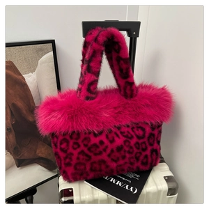 Detailed texture of pink leopard print faux fur handbag on vintage white suitcase