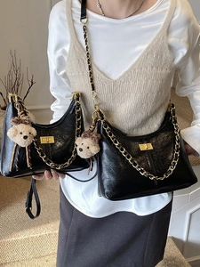Black quilted hobo bag with gold chain strap and plush bear charm in two sizes